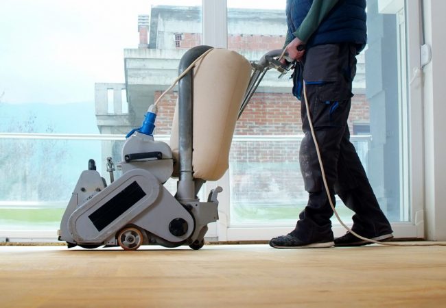 Sanding parquet with the grinding machine. Polishing, repair in apartment